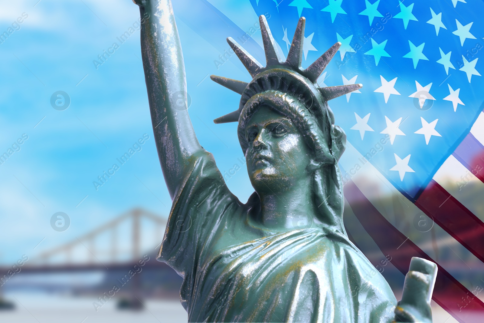 Image of Statue of Liberty against American flag and bridge