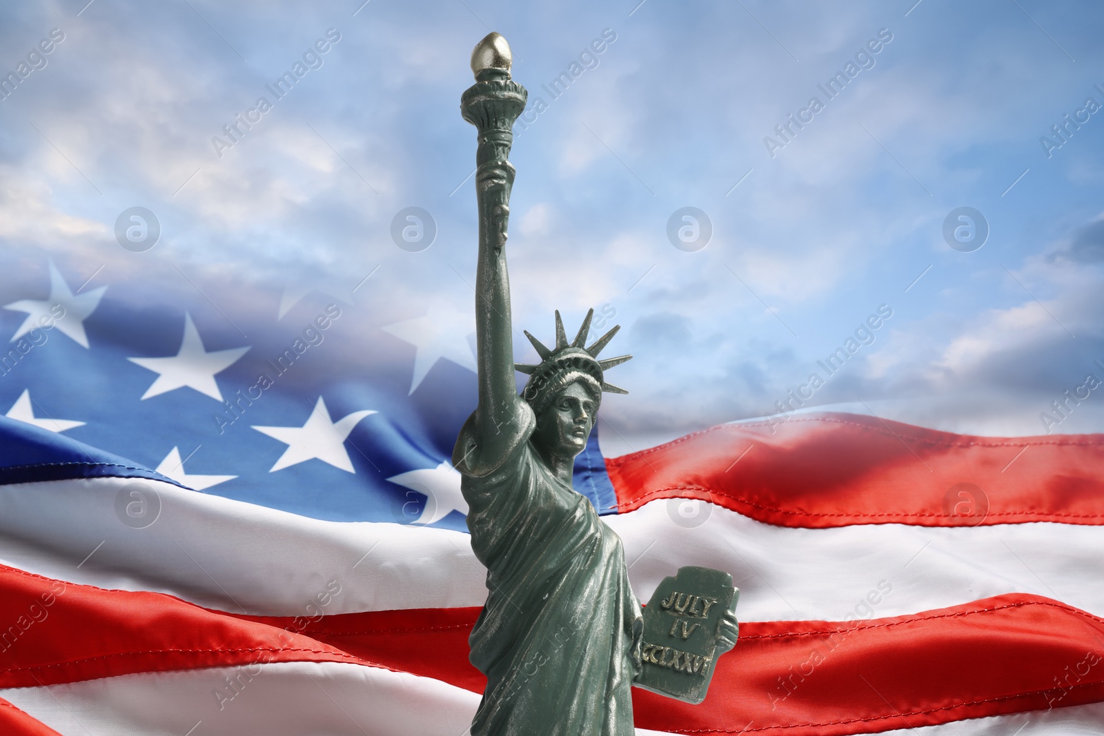 Image of Statue of Liberty against American flag and sky