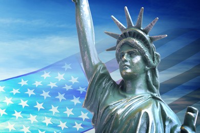 Image of Statue of Liberty against American flag and sky