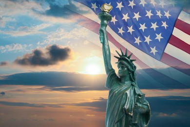 Image of Statue of Liberty against American flag and sunset sky