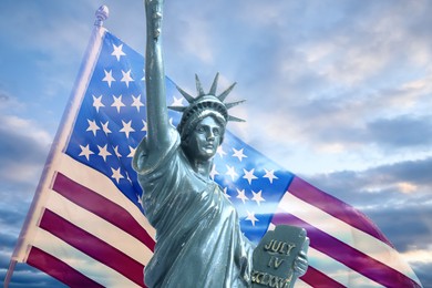 Image of Statue of Liberty against American flag and sky