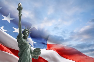 Image of Statue of Liberty against American flag and sky