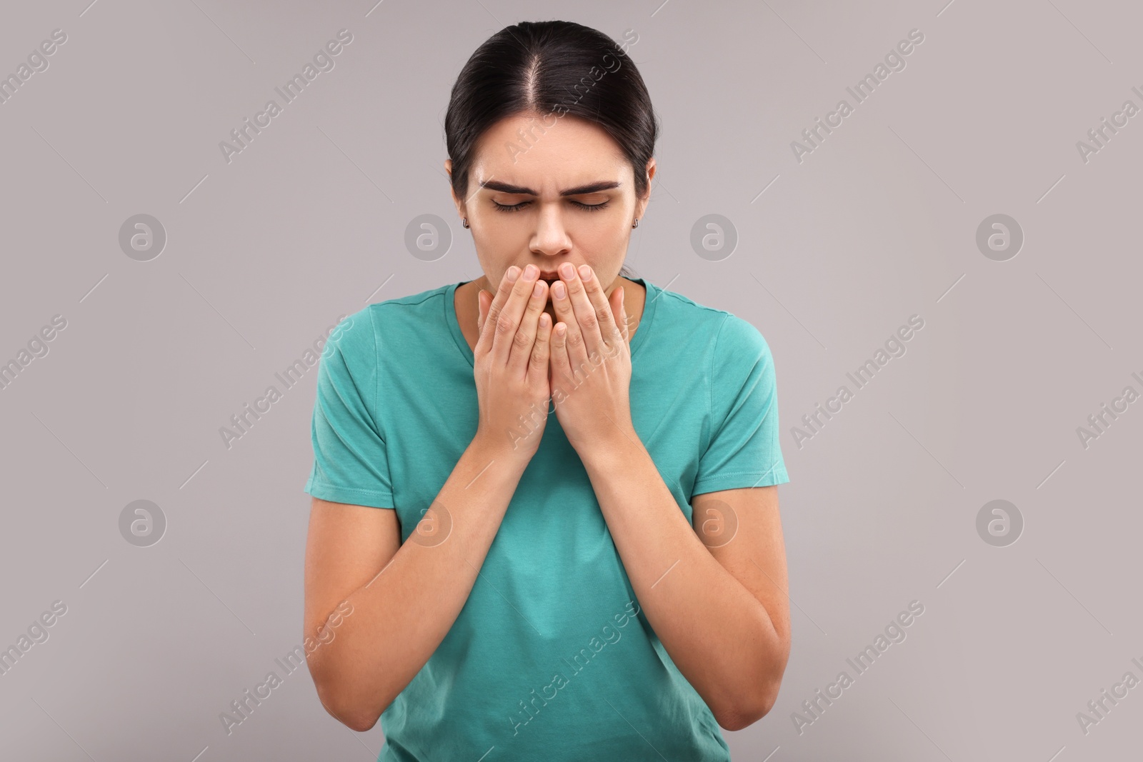 Photo of Woman coughing on grey background. Cold symptoms