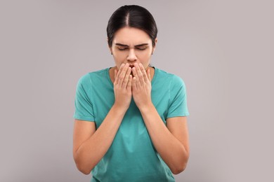 Photo of Woman coughing on grey background. Cold symptoms