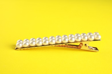 Photo of Beautiful bijouterie. Stylish hair clip on yellow background