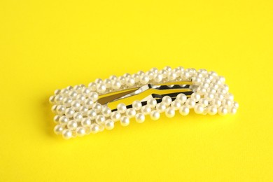 Photo of Beautiful bijouterie. Stylish hair clip on yellow background