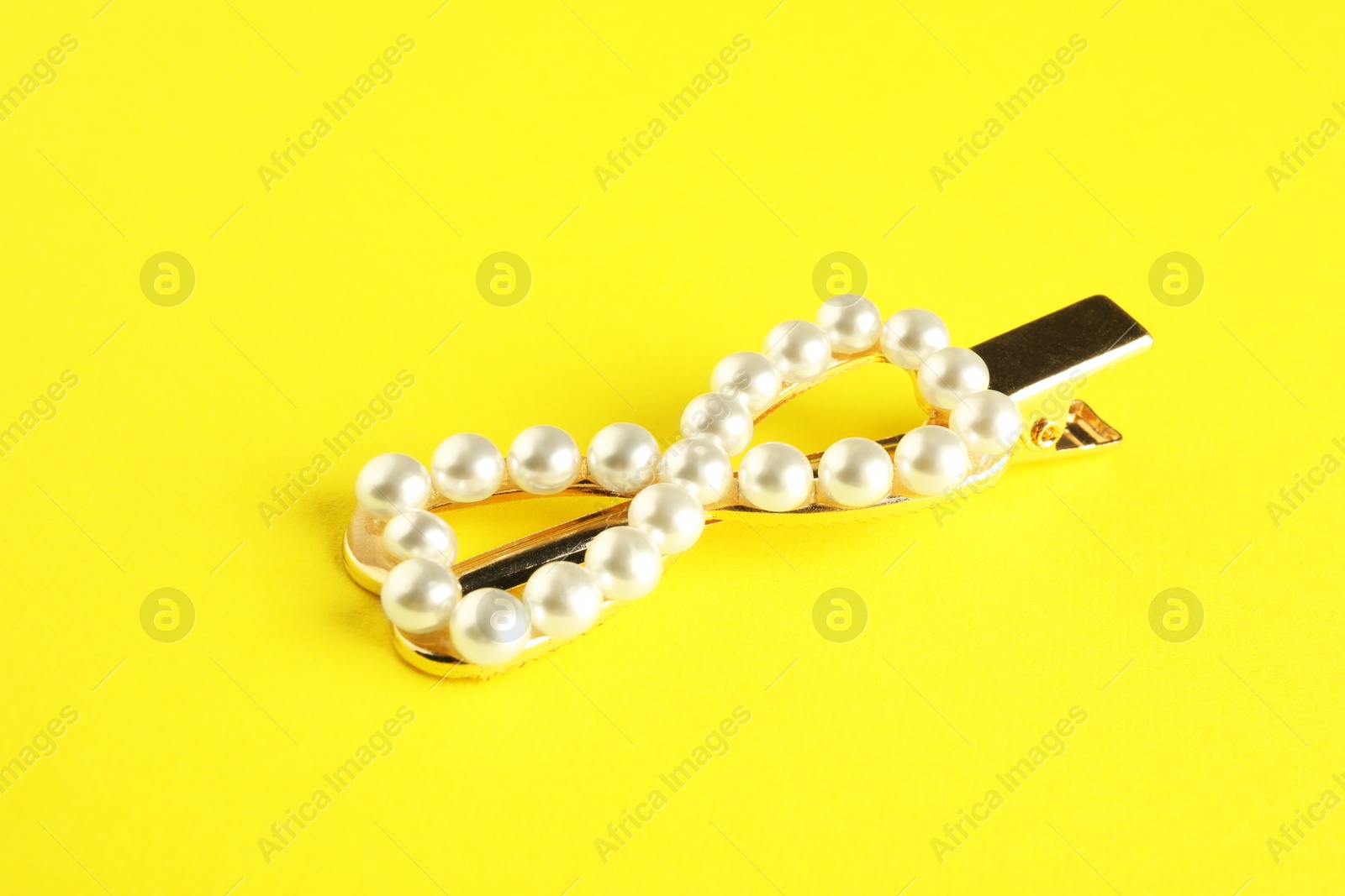 Photo of Beautiful bijouterie. Stylish hair clip on yellow background