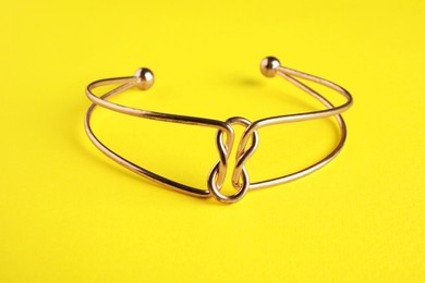 Photo of Beautiful bijouterie. Stylish bracelet on yellow background, closeup