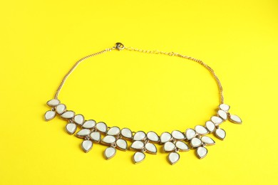 Beautiful bijouterie. Stylish necklace on yellow background