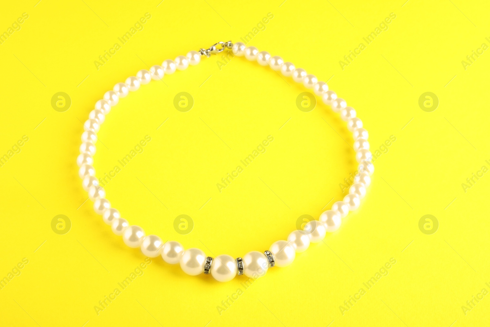 Photo of Beautiful bijouterie. Stylish bracelet on yellow background