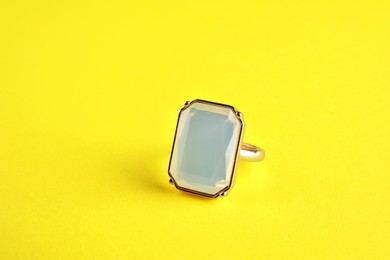 Photo of Beautiful bijouterie. Elegant ring on yellow background