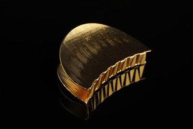 Beautiful bijouterie. Elegant hair clip on black mirror surface, closeup