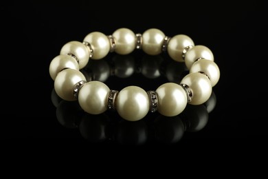 Beautiful bijouterie. Elegant bracelet on black mirror surface, closeup