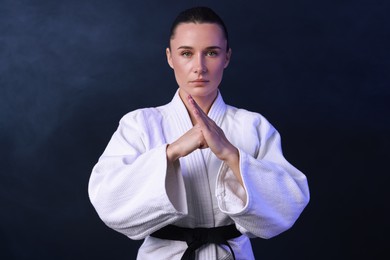 Photo of Karate fighter in kimono on dark background