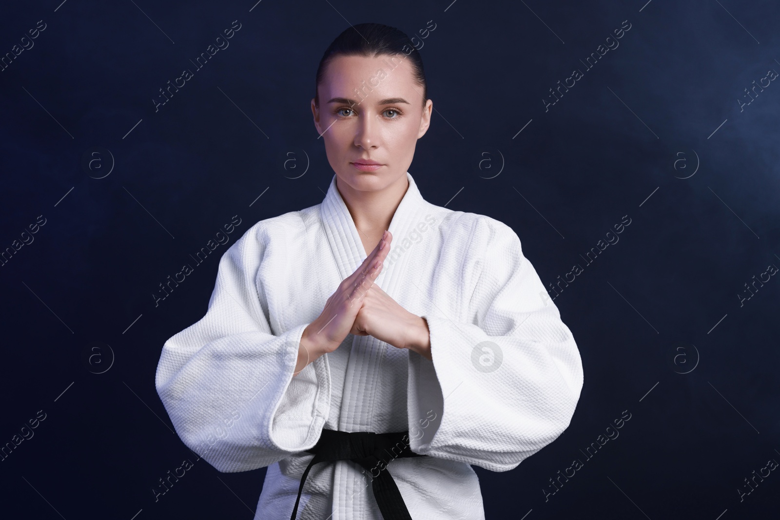 Photo of Karate fighter in kimono on dark background