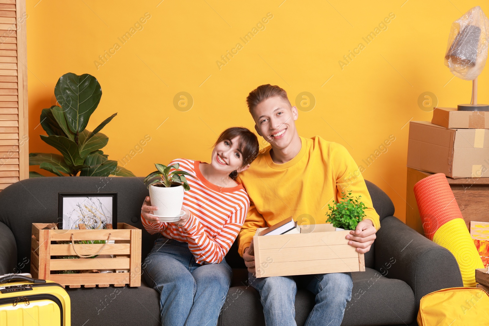 Photo of Happy couple with different stuff in new apartment. Housewarming party