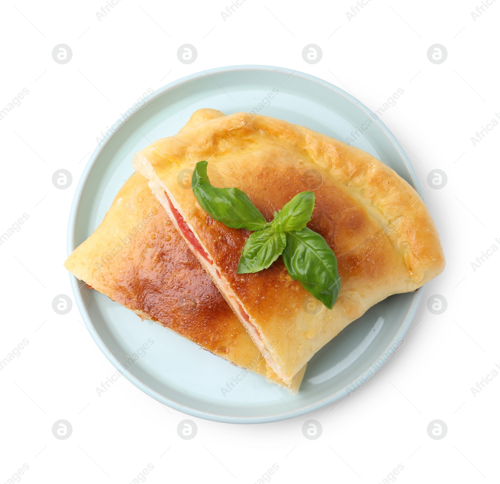 Photo of Pieces of tasty vegetarian calzone with basil isolated on white, top view