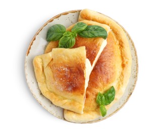 Photo of Pieces of delicious calzone pizza with mozzarella, tomatoes and basil isolated on white, top view