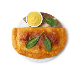 Photo of Tasty calzone with basil and sauce isolated on white, top view