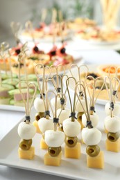 Photo of Many different tasty canapes on white table, closeup