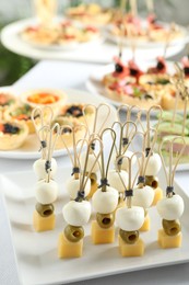 Photo of Many different tasty canapes on white table, closeup