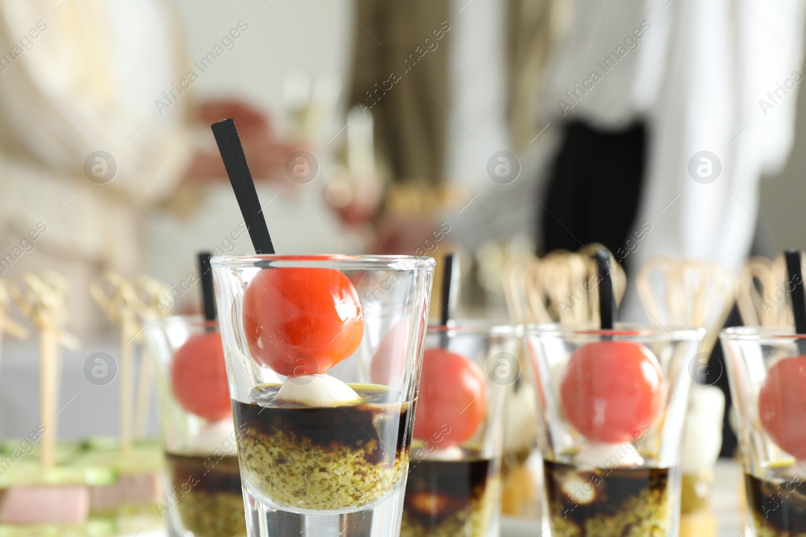 Photo of Many different tasty canapes against blurred background. People enjoying buffet meals indoors, closeup