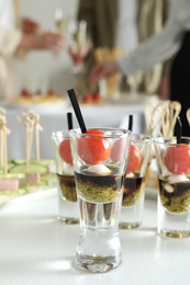 Photo of Many different tasty canapes on white table. People enjoying buffet meals indoors, closeup