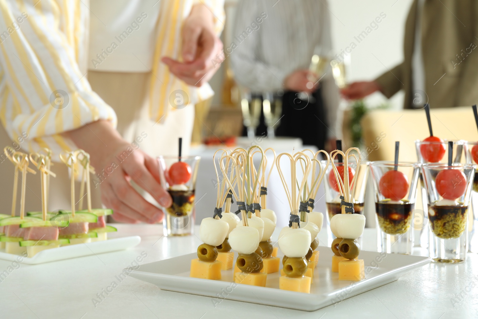 Photo of Many different tasty canapes on white table. People enjoying buffet meals indoors, closeup