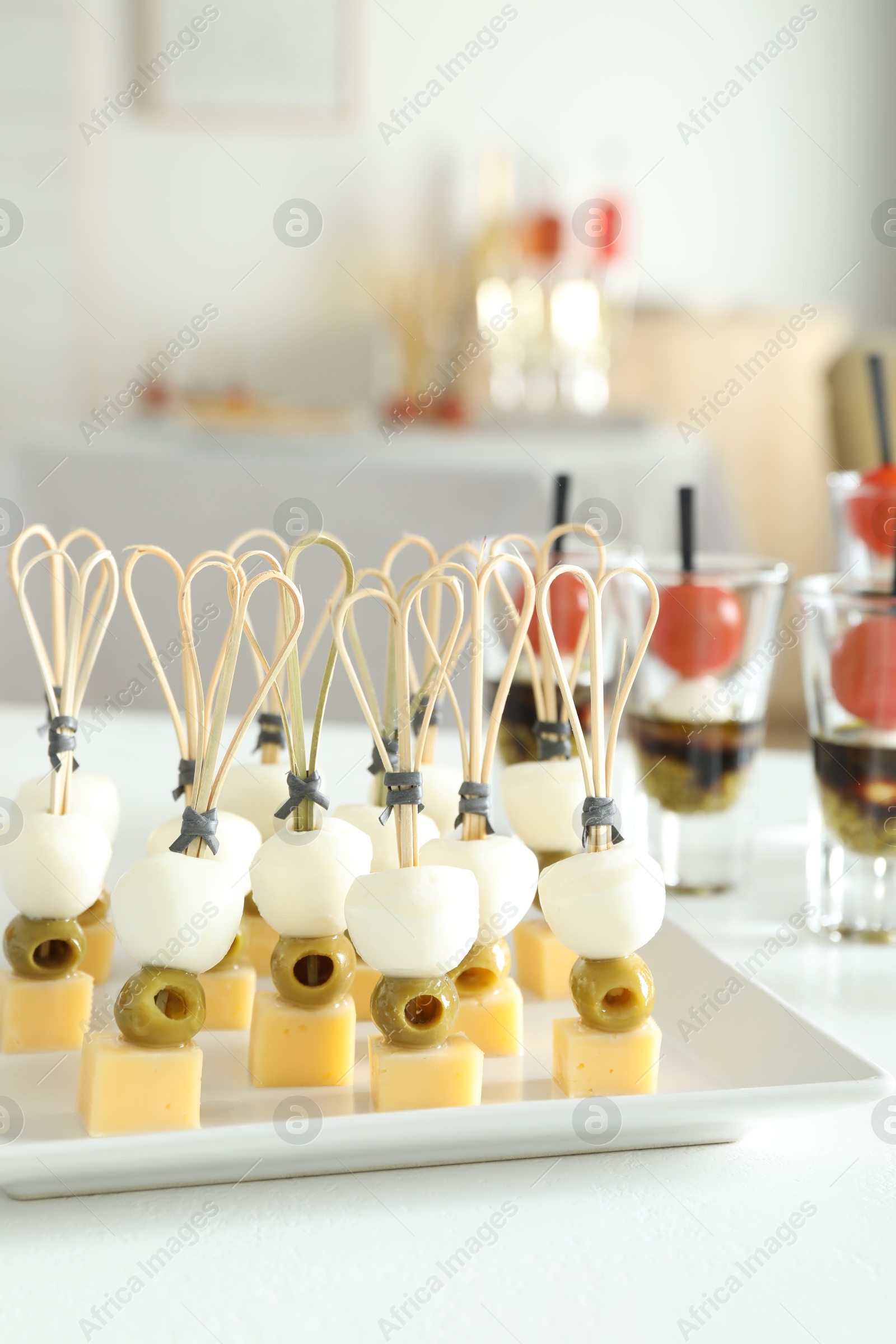 Photo of Many different tasty canapes on white table indoors