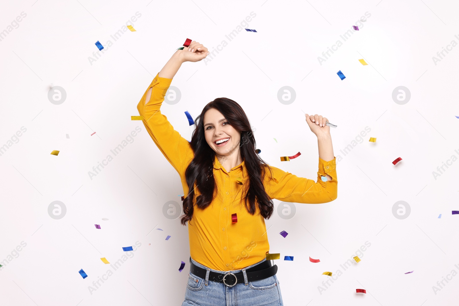 Photo of Happy woman under falling confetti on white background. Surprise party