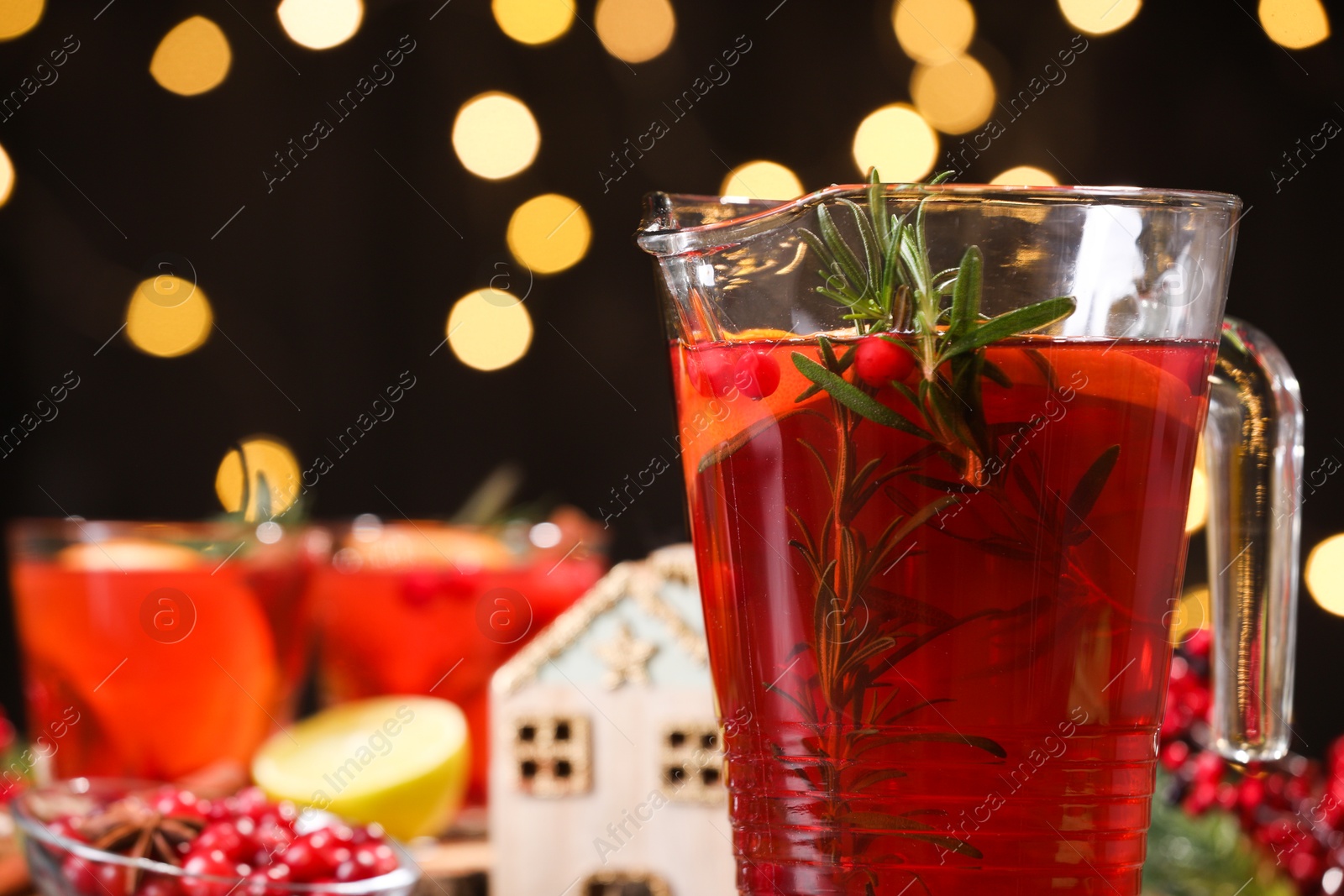 Photo of Tasty punch in glass jug against blurred background, closeup