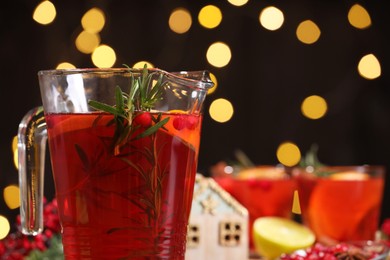 Photo of Tasty punch in glass jug against blurred background, closeup