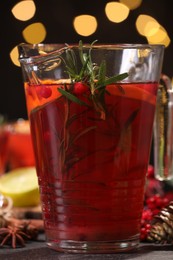 Photo of Tasty punch drink in glass jug on dark table against blurred lights, closeup