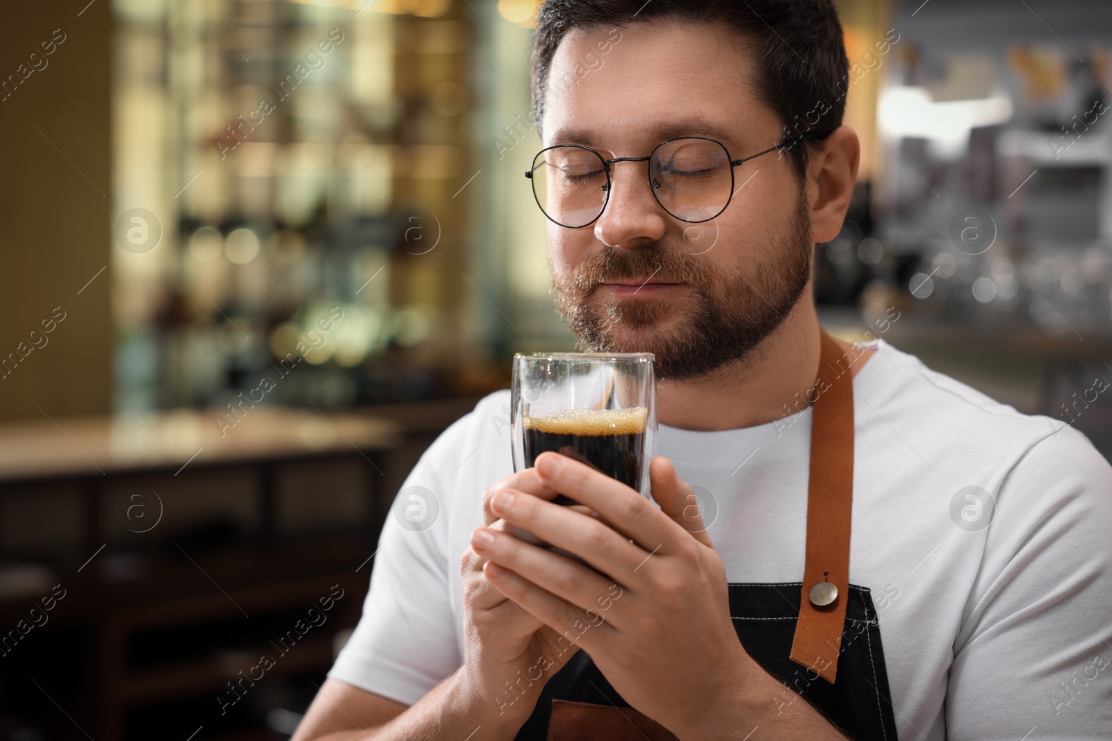 Photo of Barista sniffing aromatic filter coffee in cafe