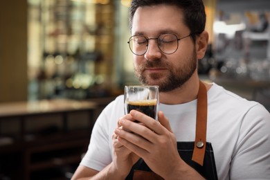 Barista sniffing aromatic filter coffee in cafe