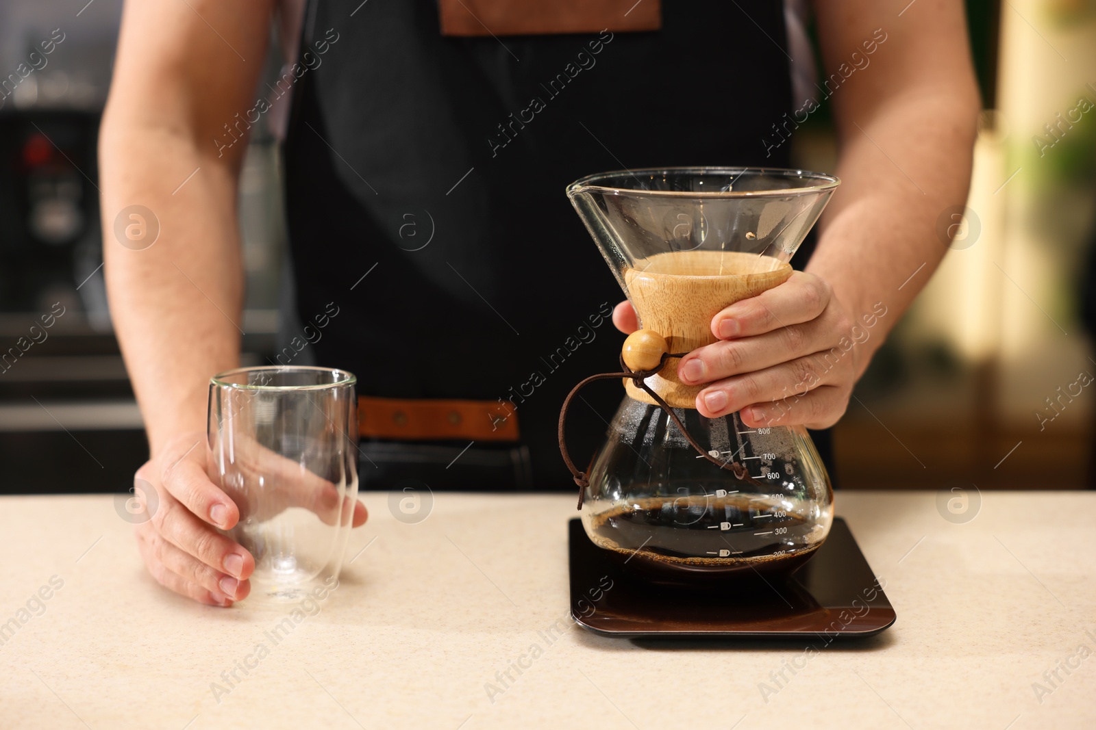 Photo of Barista with aromatic filter coffee at table in cafe, closeup