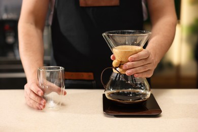 Barista with aromatic filter coffee at table in cafe, closeup