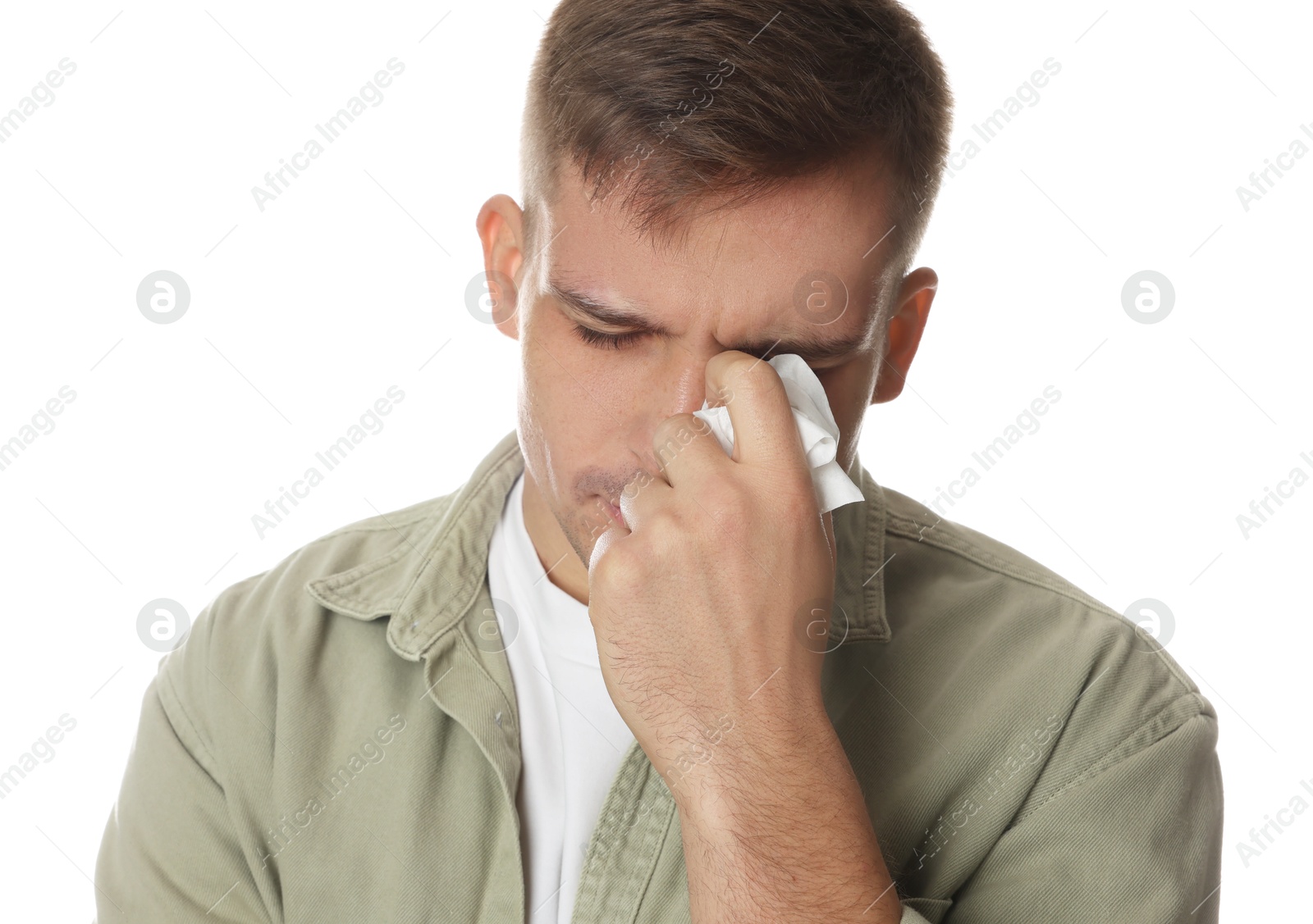 Photo of Crying man wiping tears with tissue on white background