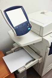 Photo of Modern printer with paper indoors. Printing house