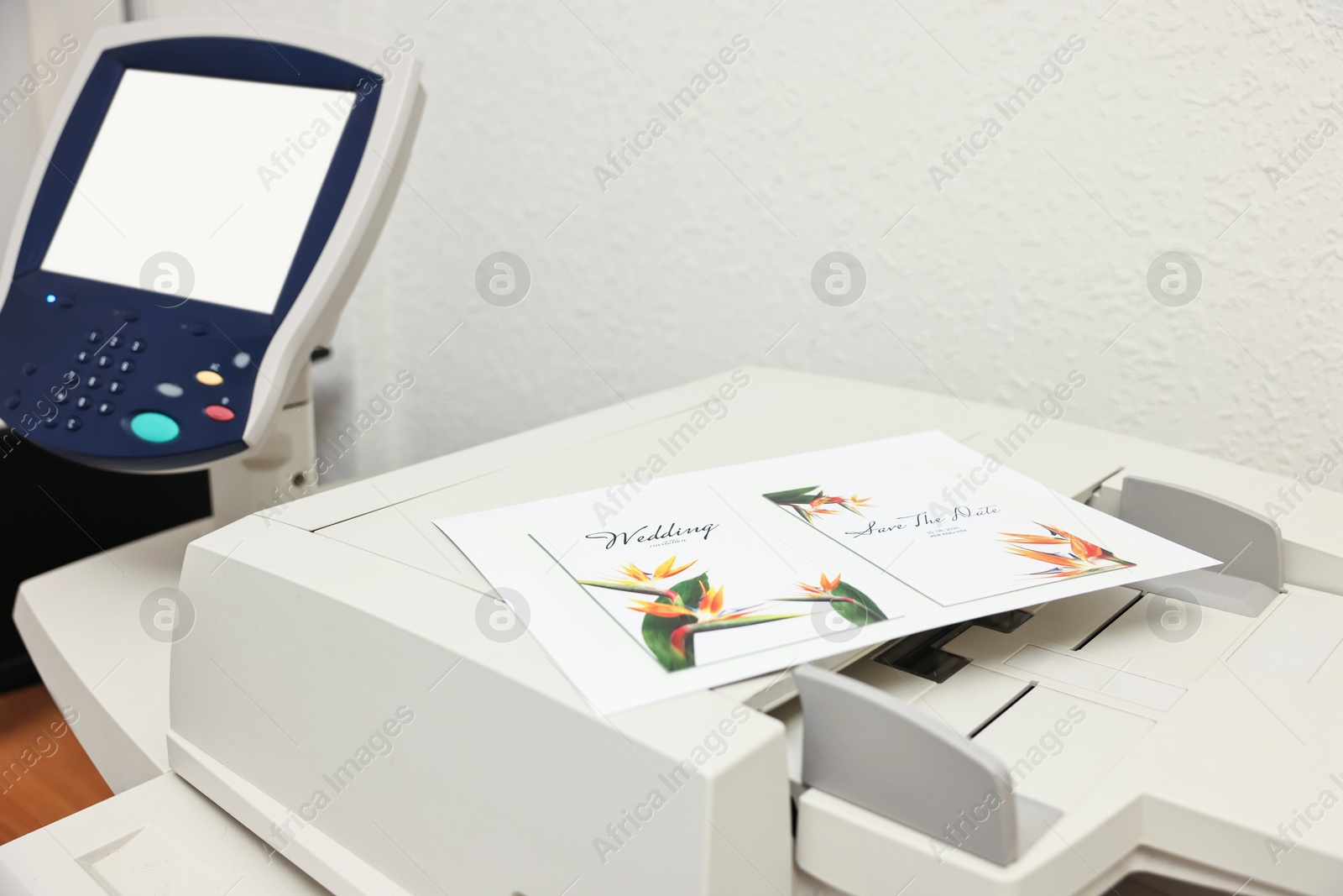 Photo of Modern printer with printed wedding invitation cards indoors, closeup. Printing house