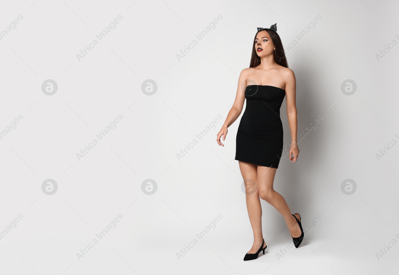 Photo of Attractive woman with cat makeup and ears on white background