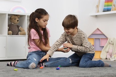 Children playing with balancing stones on floor indoors