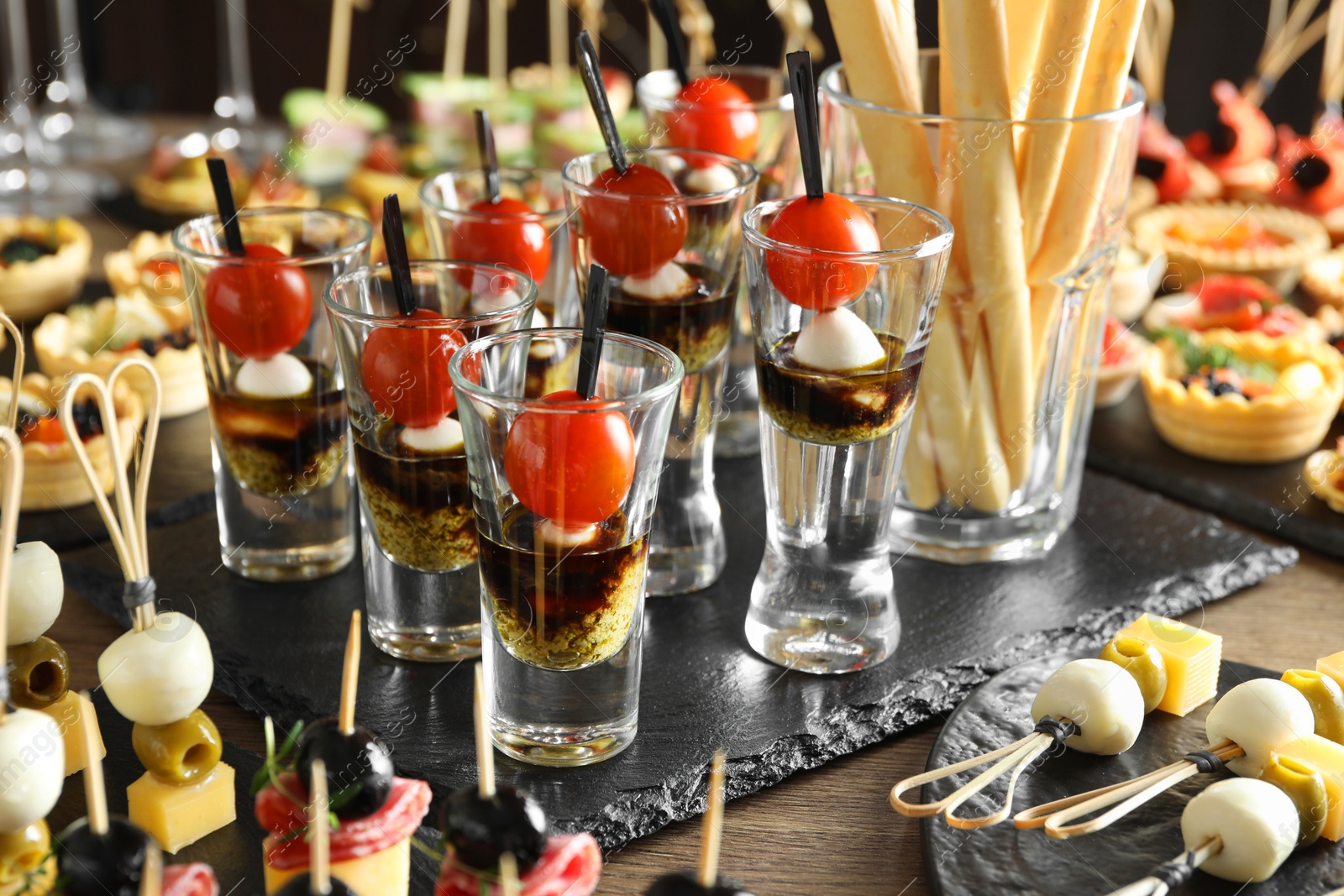 Photo of Many different tasty canapes on wooden table, closeup