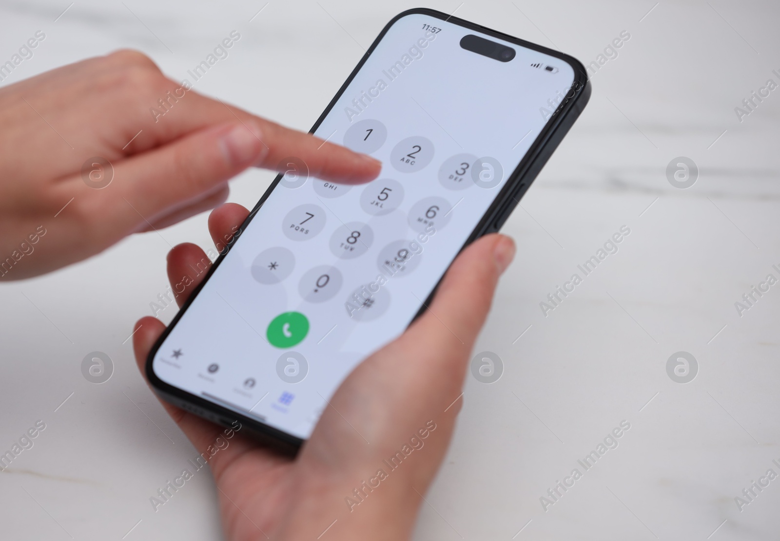 Photo of Woman dialing number on smartphone at white marble table, closeup