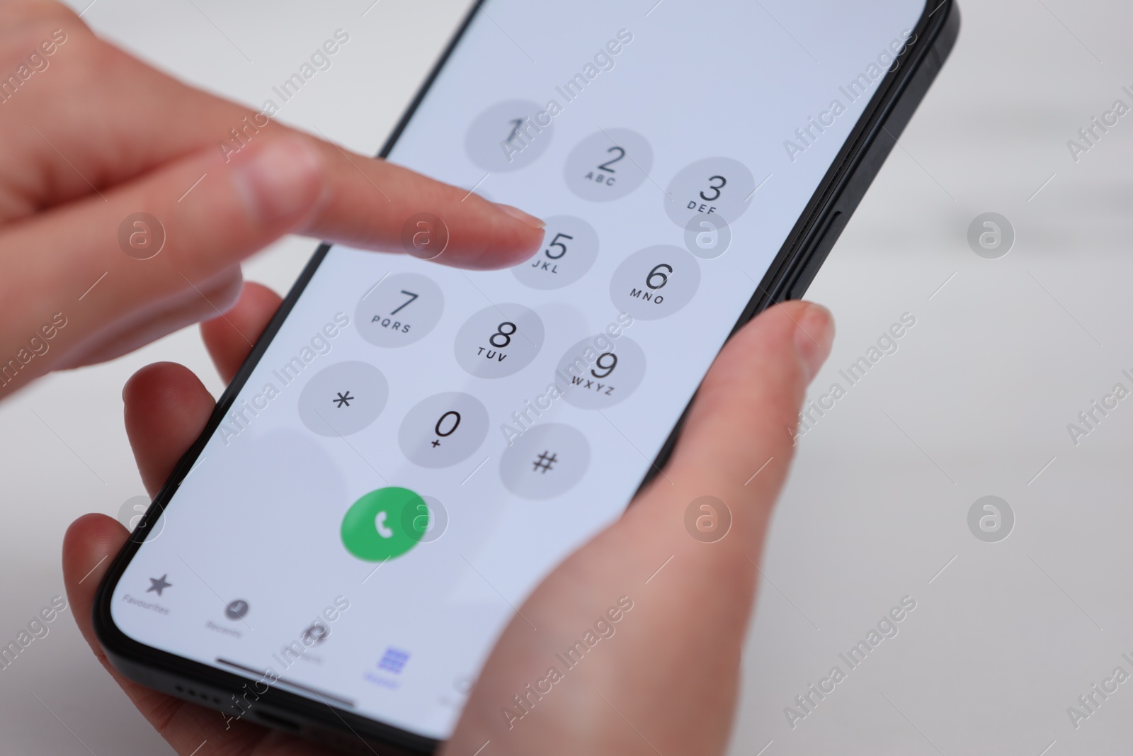 Photo of Woman dialing number on smartphone against blurred background, closeup