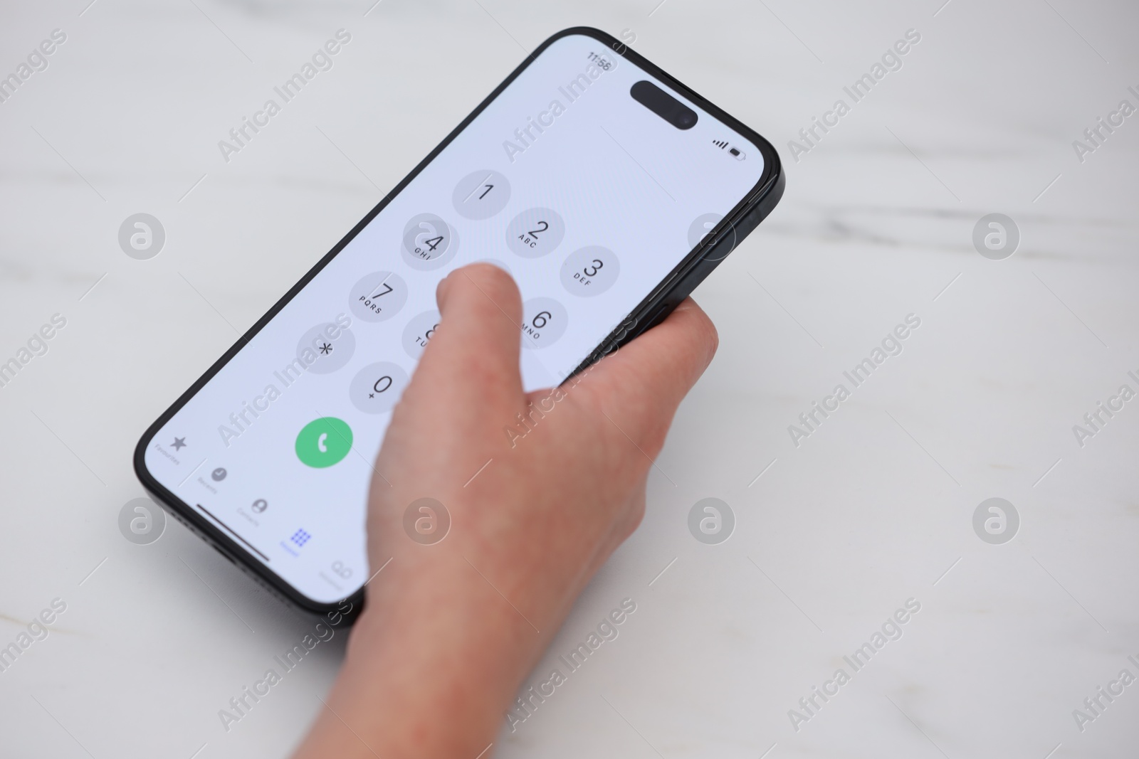 Photo of Woman dialing number on smartphone at white marble table, closeup