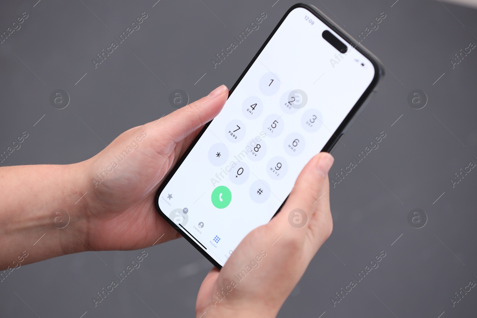 Photo of Woman holding smartphone with dialer application against blurred grey background, closeup