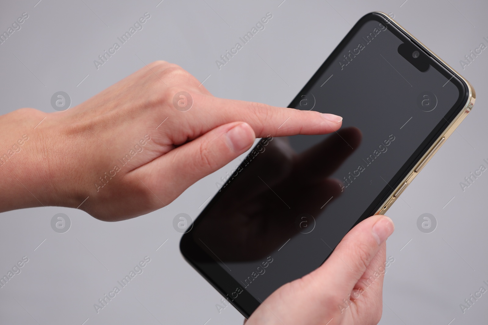 Photo of Woman using smartphone with blank screen on grey background, closeup