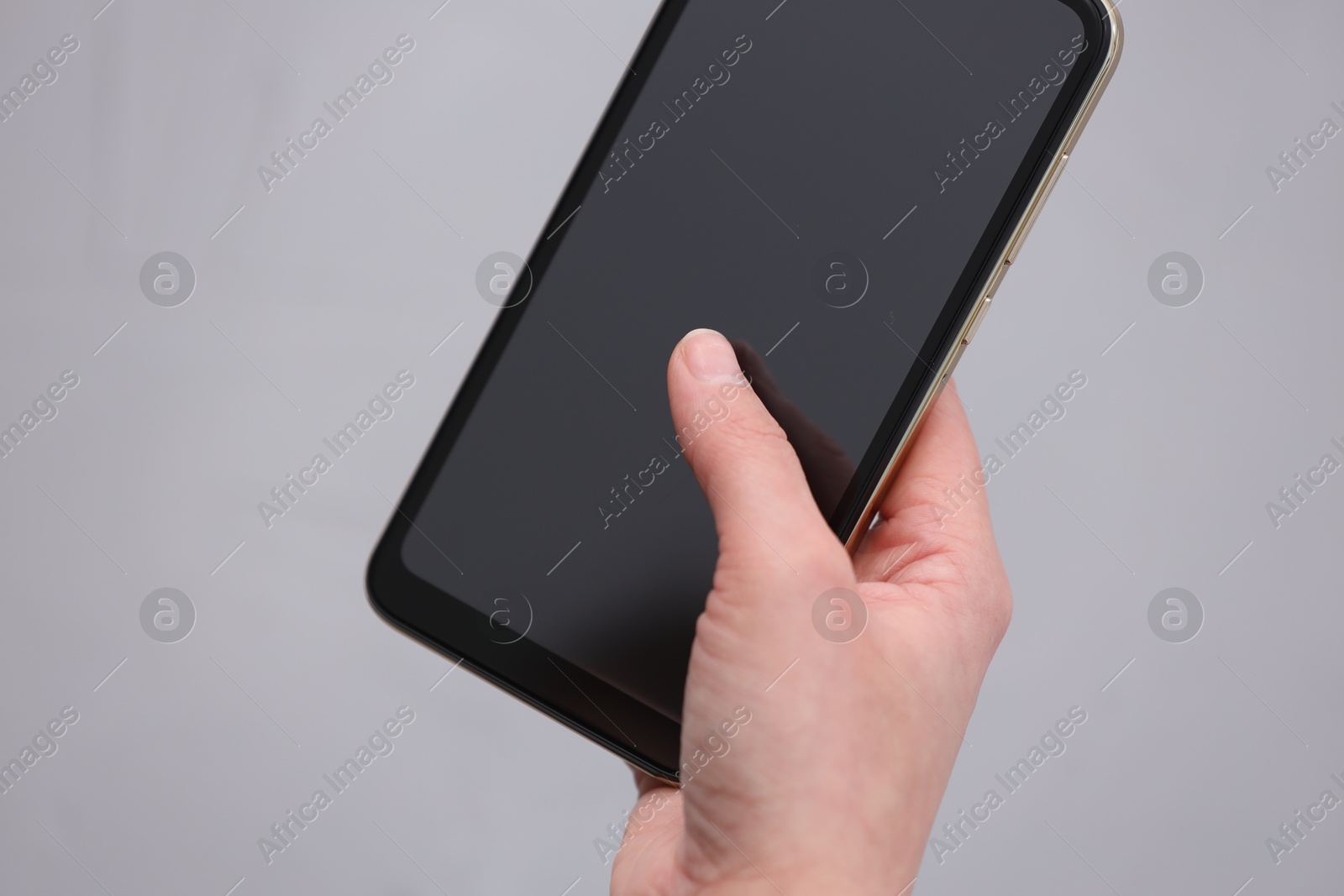 Photo of Woman using smartphone with blank screen on grey background, closeup