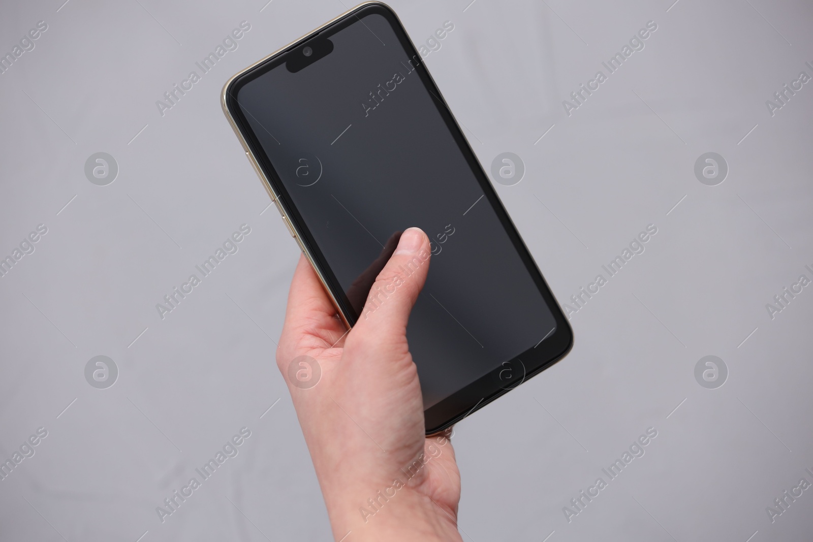 Photo of Woman using smartphone with blank screen on grey background, closeup